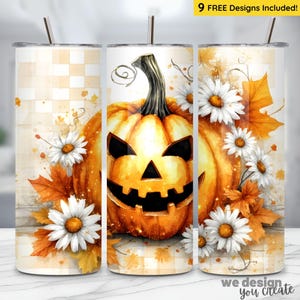 Puede incluir: Juego de tres vasos de acero inoxidable con un diseño temático de Halloween. El diseño presenta una calabaza tallada, margaritas blancas y hojas de otoño naranjas. El texto "9 FREE Designs Included!" es visible.