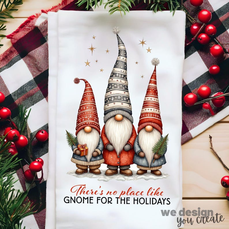 K&ouml;nnte beinhalten: Wei&szlig;es K&uuml;chentuch mit Weihnachtsmotiv, das drei Wichtel mit langen, spitzen H&uuml;ten und wei&szlig;en B&auml;rten zeigt. Die Wichtel halten ein Geschenk und einen kleinen Baum. Der Text "There's no place like gnome for the holidays" ist darunter gedruckt.