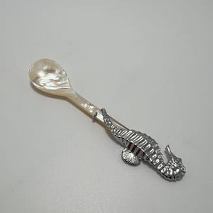 Cuillère à caviar artisanale en coquillage naturel avec manche sculpté en forme d'hippocampe, idéale pour les gâteaux, le caviar, la glace et les enfants.