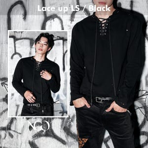 May include: A black long-sleeve shirt featuring a lace-up front closure with silver-toned metal eyelets and long black cord ties. The shirt has a round neckline and a plain black fabric construction. The text "Lace up LS / Black" is visible.