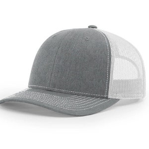 May include: A gray and white trucker hat with a mesh back. The hat has a curved brim and a white stitching detail.