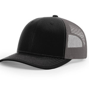 May include: A black and gray trucker hat with a mesh back. The hat has a curved brim and a structured crown.
