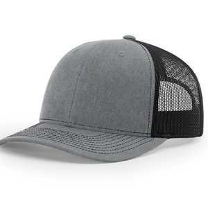 May include: A gray and black trucker hat with a mesh back. The hat has a curved brim and a structured crown.