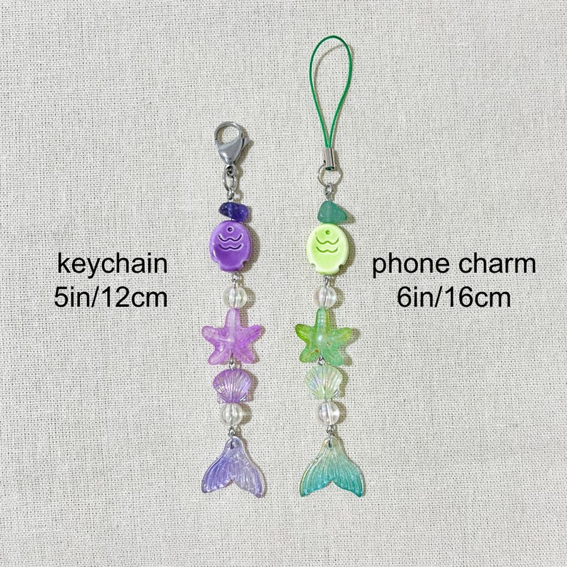 May include: Two beaded mermaid-themed accessories: a keychain (5 inches/12 cm) and a phone charm (6 inches/16 cm). The keychain features purple beads, a starfish, a shell, and a mermaid tail. The phone charm has green beads, a starfish, a shell, and a mermaid tail.