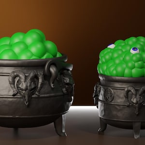 May include: Two black cauldrons with three legs, featuring embossed ram skull and pentagram designs on the exterior. Each cauldron is filled with a mound of bright green spheres, with a single blue and white eye visible within the green mass.
