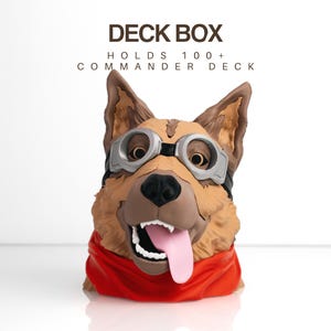 May include: A deck box shaped like a brown dog head wearing silver goggles and a red scarf, with the text DECK BOX HOLDS 100+ COMMANDER DECK printed above. The dog has pointed ears, a black nose, and an open mouth with a pink tongue.