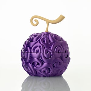 Könnte beinhalten: Eine 3D-gedruckte lila Frucht mit wirbelnder Textur und einem beigen Stiel. Das kugelförmige Objekt befindet sich vor einem weißen Hintergrund, mit einer leichten Reflexion darunter. Das Design erinnert an einen Fantasy- oder Anime-inspirierten Artikel.