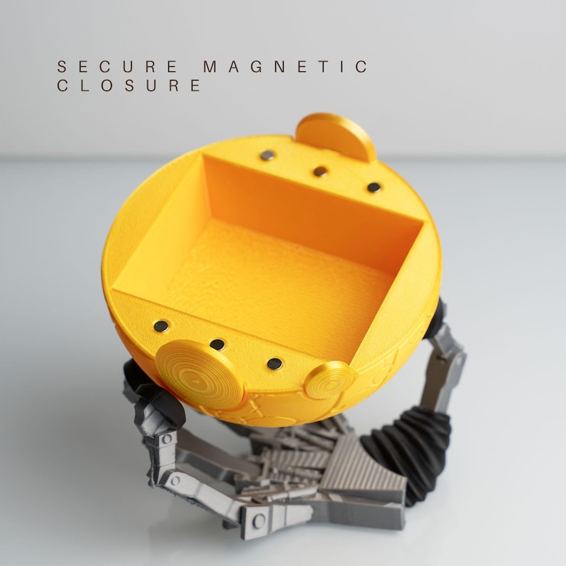 a yellow, circular object with a metallic, robotic-like appearance, sitting on a gray base.
