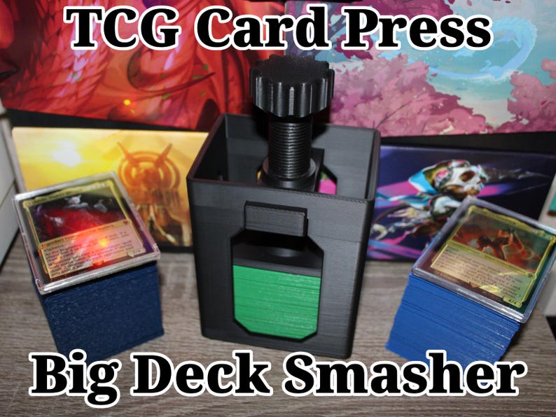 May include: Black TCG card press with a green accent, designed to flatten trading cards. The text "TCG Card Press" and "Big Deck Smasher" are displayed. Stacks of cards are visible on blue foam blocks.
