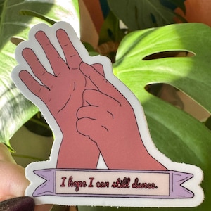 Puede incluir: Una pegatina con un gesto de mano rosa y el texto "Espero poder seguir bailando."