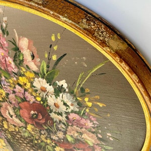 Pu&ograve; includere: Un dipinto ovale vintage incorniciato di un bouquet di fiori colorati in un cesto intrecciato. I fiori sono dipinti in tonalit&agrave; di rosa, rosso, bianco, giallo e verde. La cornice &egrave; di colore oro invecchiato.
