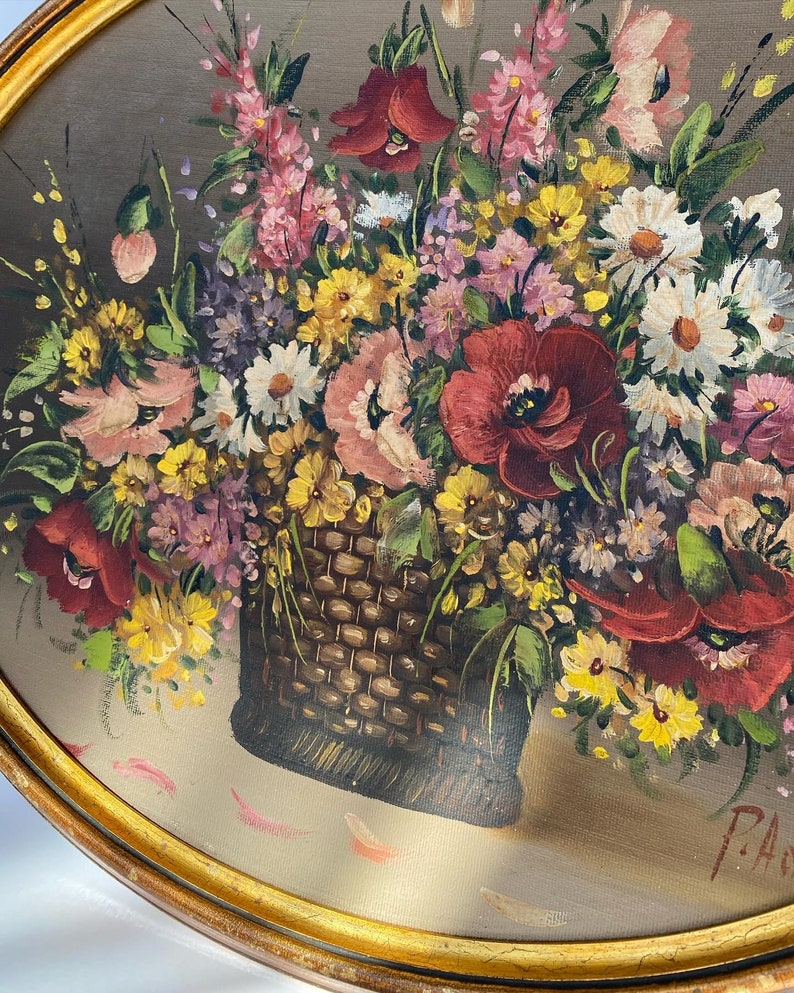 Pu&ograve; includere: Un dipinto incorniciato che raffigura un cesto traboccante di una variet&agrave; di fiori colorati, tra cui papaveri rossi, fiori rosa e margherite gialle. Il cesto &egrave; intrecciato e marrone, e i fiori sono disposti in uno stile naturale e fluido.