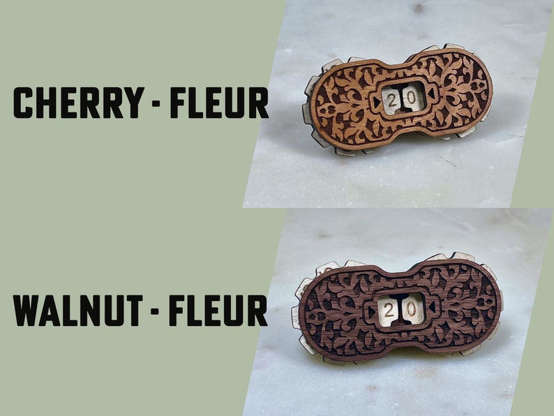 May include: Two wooden counter tops with intricate floral designs. The counter tops are labeled "CHERRY - FLEUR" and "WALNUT - FLEUR". Each counter top has a small, white, wooden number "20" displayed in a window.