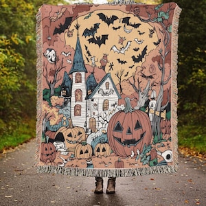 Könnte beinhalten: Eine gewebte Wandbehang mit einer gruseligen Halloween-Szene mit einem Spukhaus, Fledermäusen, Kürbissen und einem Vollmond. Der Wandbehang ist in Orange-, Braun-, Gelb- und Blautönen gehalten.