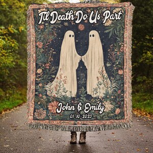K&ouml;nnte beinhalten: Eine Wandteppich-Decke mit dunkelblauem Hintergrund, auf der zwei wei&szlig;e Geister mit floralen Akzenten zu sehen sind. Der Text "Til Death Do Us Part" befindet sich oben auf der Decke, und die Namen "John & Emily" sowie das Datum "01-10-2023" befinden sich unten.