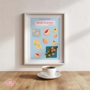 Può includere: Una stampa artistica incorniciata con illustrazioni di pesche e la scritta "FRESH PEACHES" su sfondo azzurro. La stampa include un ghiacciolo alla pesca. Una tazza da caffè e un piattino bianchi sono su una superficie di legno.