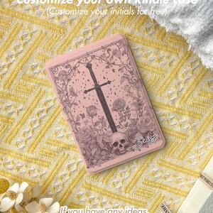 Peut inclure: &Eacute;tui Kindle rose avec un motif floral et une t&ecirc;te de mort, avec une &eacute;p&eacute;e. L'&eacute;tui porte le texte "Customize your own kindle case" et "Customize your initials for free". Le nom "Daisy" est &eacute;galement visible.