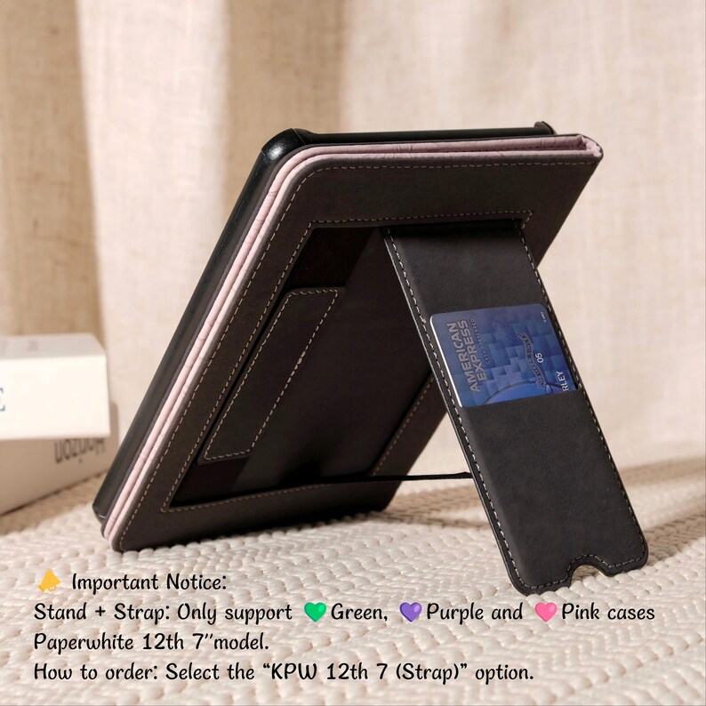 May include: A black leather tablet case with a pink border and a built-in stand. The case has a card slot with an American Express card. The text on the case says "Paperwhite 12th 7" model".