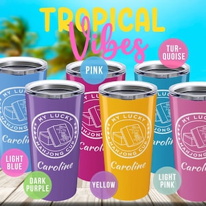 May include: A collection of colorful insulated tumblers with the text "My Lucky Mahjong Cup Caroline." The tumblers are in light blue, dark purple, yellow, light pink, and turquoise. The background features the words "Tropical Vibes."