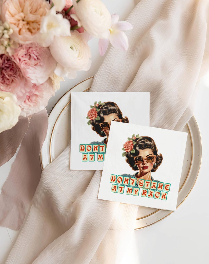 Op de afbeelding: Twee vierkante witte cocktailservetten met een vintage illustratie van een vrouw met een zonnebril en een bloem in haar haar. De tekst "DON'T STARE AT MY RACK" staat in groene en gele blokletters op de servetten.