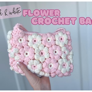 Puede incluir: Bolso de flores de crochet rosa y blanco. El bolso está hecho de flores de crochet y tiene una correa.
