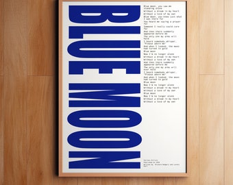 Pode incluir: Uma impressão emoldurada da letra da música "Blue Moon" de Richard Rodgers e Lorenz Hart. A letra está impressa em texto preto sobre um fundo branco. A palavra "BLUE MOON" está impressa em letras grandes, em negrito e azuis.