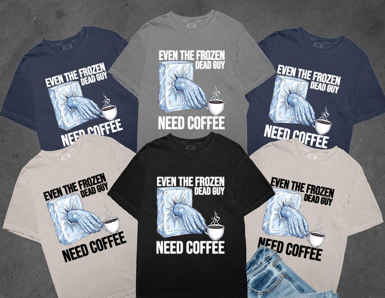 May include: A collection of t-shirts in various colors, including navy, gray, and black. Each shirt features the text "EVEN THE FROZEN DEAD GUY NEED COFFEE" with a graphic of a hand reaching out of ice to hold a coffee cup.