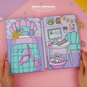 Puede incluir: Una descarga digital imprimible de una casa de mu&ntilde;ecas con tem&aacute;tica de sirena. La casa de mu&ntilde;ecas cuenta con una cama con una manta de cola de sirena, un escritorio con una pantalla de computadora que dice "C&oacute;mo dibujar una sirena" y una silla. La casa de mu&ntilde;ecas est&aacute; decorada con conchas marinas, estrellas y otras decoraciones con tem&aacute;tica de sirenas.