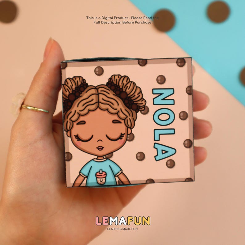 May include: A small, square box featuring a cartoon girl with brown hair and the name "NOLA" in blue. The box is light pink with brown polka dots. The text "This is a Digital Product - Please Read the Full Description Before Purchase" is at the top.