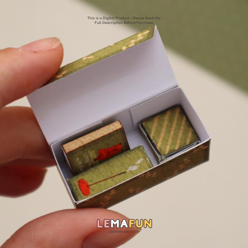 Pu&ograve; includere: Una scatola di fiammiferi in miniatura con un esterno a motivi verdi e marroni, contenente piccoli libri dettagliati e un quadrato a motivi. Il testo "This is a Digital Product - Please Read the Full Description Before Purchase" &egrave; visibile. Anche il logo "LEMAFUN" &egrave; visibile.