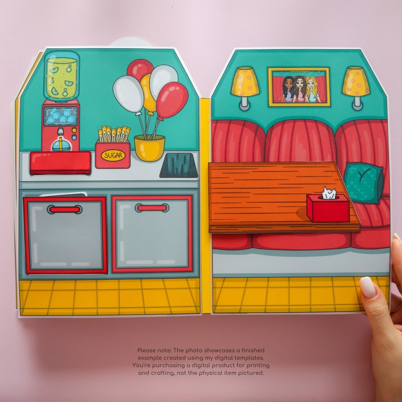 May include: A printable paper craft kit for a diner with a red and white booth, a counter with a drink dispenser, and a sign that says "SUGAR". There are balloons in the background.