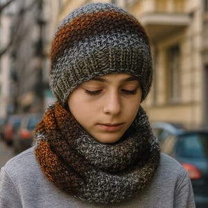 Puede incluir: Conjunto de gorro y cuello tejidos en tonos marrón, gris y verde oliva. El gorro presenta rayas horizontales y el cuello es un bucle sin costuras. El conjunto está hecho de hilo suave y texturizado, ideal para el invierno.