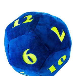 Könnte beinhalten: Ein blauer Plüschwürfel mit gelben Zahlen 1, 2, 6, 10 und 12.