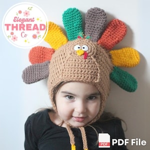 May include: A crocheted turkey hat with a brown body, colorful feathers, and a cute turkey face. The hat has a tie string and is perfect for a child.