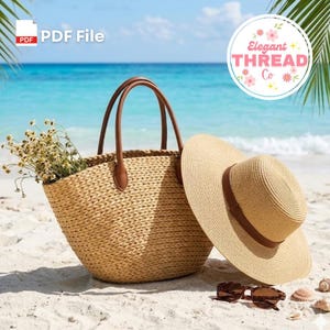 May include: A woven straw tote bag with brown leather handles and a wide-brimmed straw hat sit on a sandy beach. The tote is filled with dried flowers. Sunglasses and seashells are also on the sand. The Elegant Thread Co. logo is in the background.