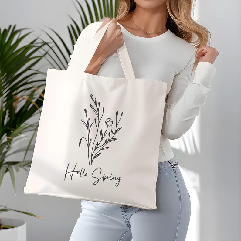 May include: A white canvas tote bag with black floral line art and the text "Hello Spring".