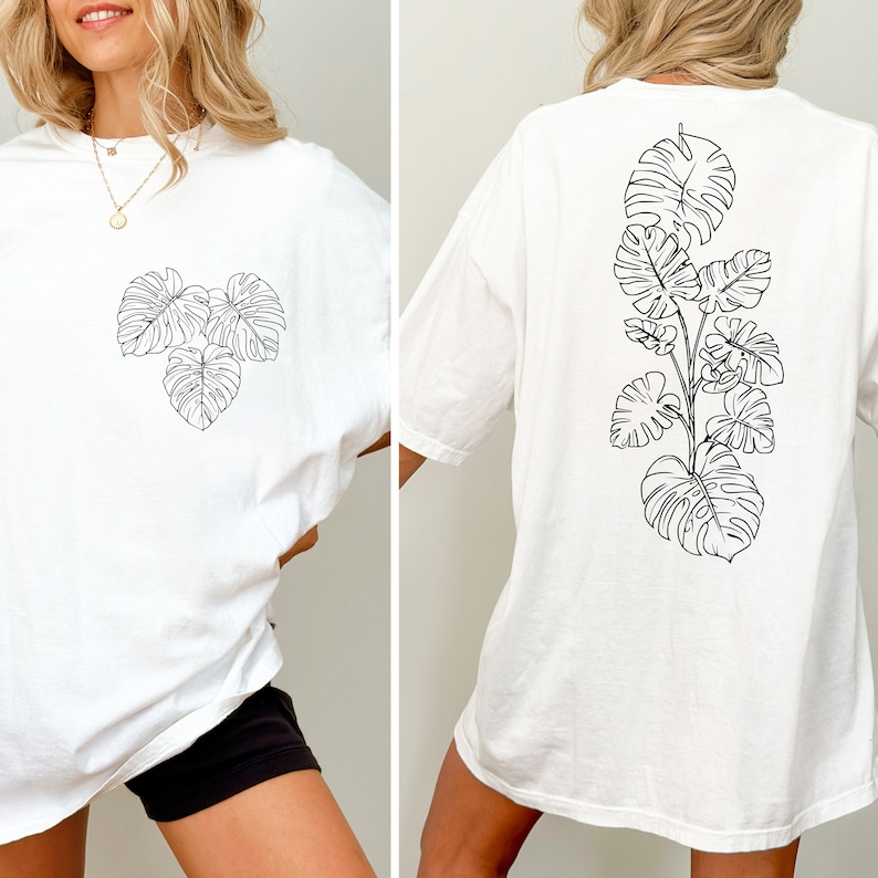 K&ouml;nnte beinhalten: Wei&szlig;es Oversize-T-Shirt mit einer schwarzen Linienzeichnung von tropischen Bl&auml;ttern auf Vorder- und R&uuml;ckseite.