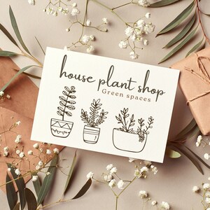May include: A white card with black text that reads "house plant shop Green spaces". The card features three illustrations of potted plants.