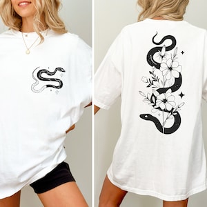 May include: White oversized t-shirt with a black snake and flower graphic on the back and a smaller snake graphic on the front.