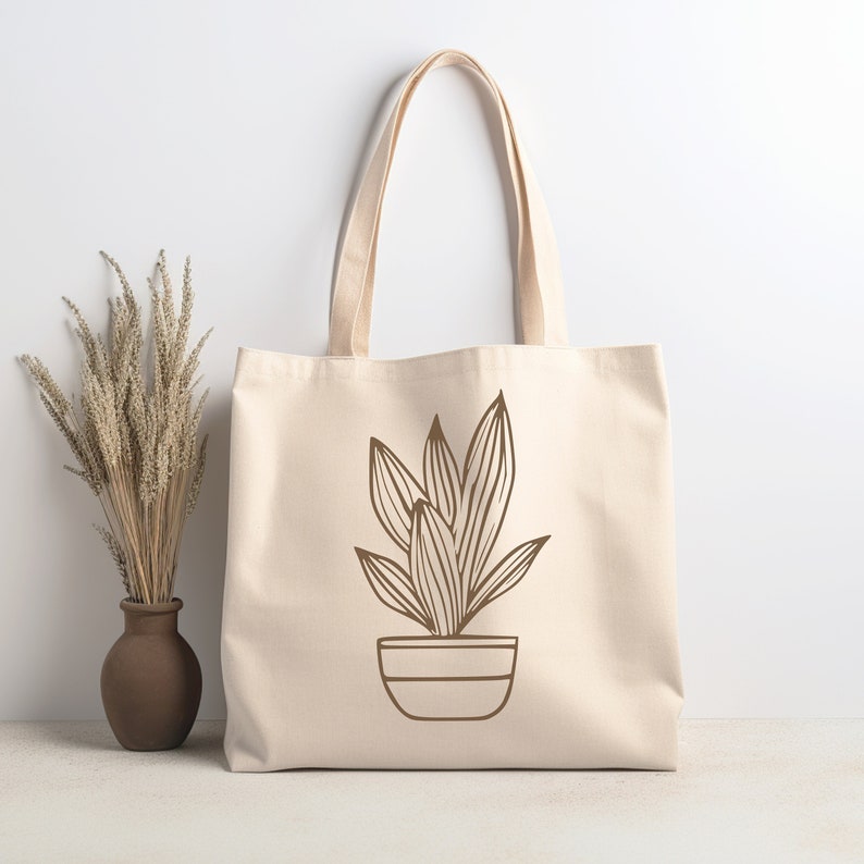 May include: A beige tote bag with a brown line drawing of a potted plant on the front.