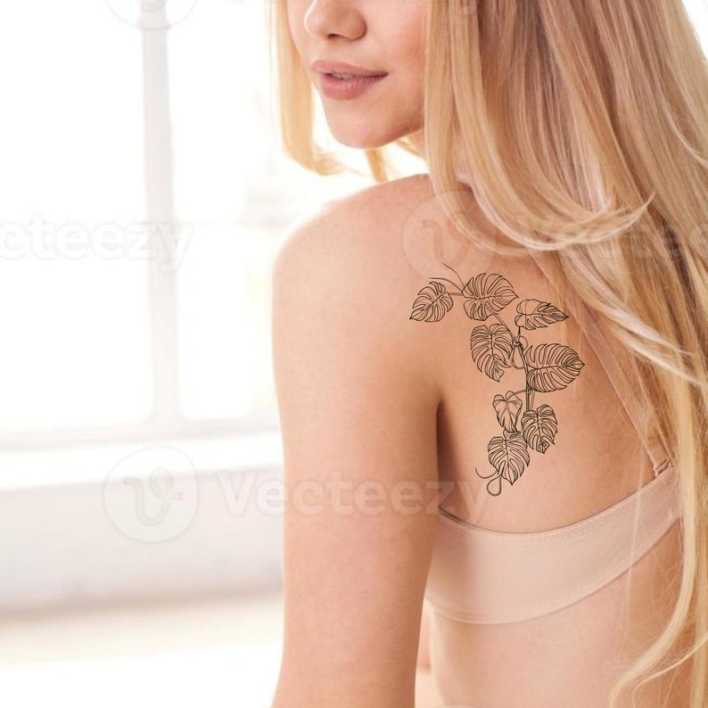 K&ouml;nnte beinhalten: Die Schulter einer Frau mit einem tempor&auml;ren Tattoo einer Rebe mit Bl&auml;ttern.