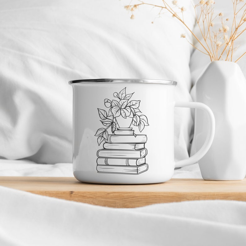 May include: White enamel mug with a black line drawing of a potted plant on top of a stack of books. The mug has a handle.