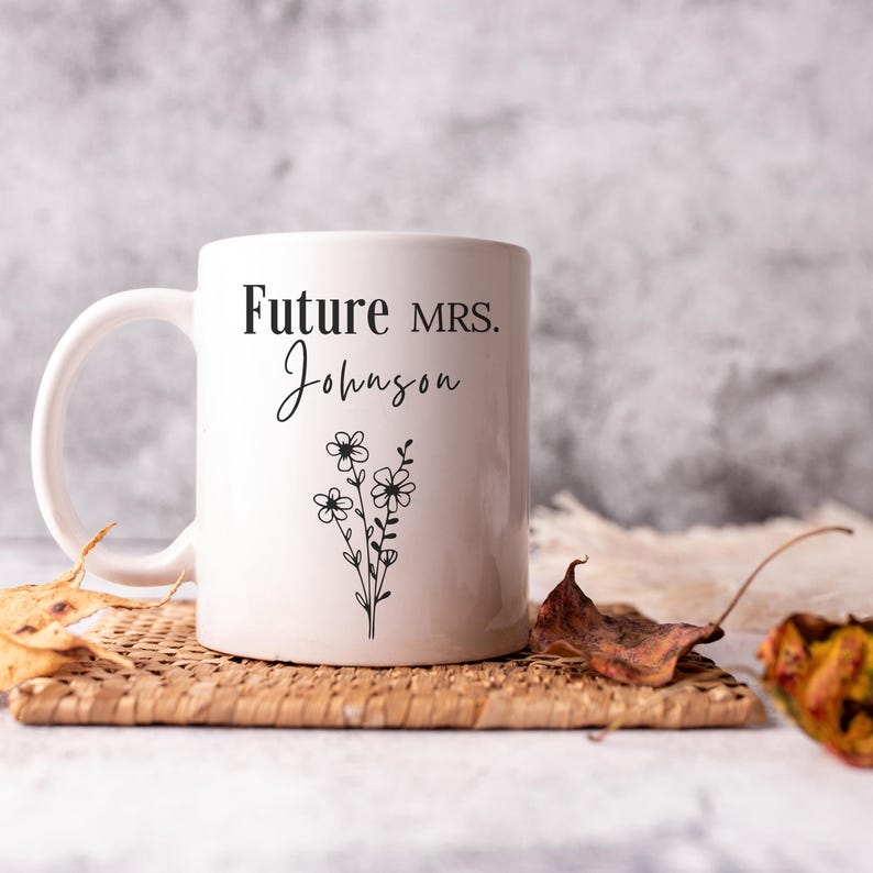 May include: White ceramic mug with black text that reads "Future MRS. Johnson" and a small floral design.