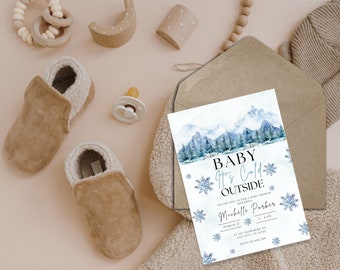 Op de afbeelding: Een uitnodiging voor een babyshower met een aquarel-illustratie van een besneeuwde bergketen en de tekst "Baby It's Cold Outside". De uitnodiging is voor een babyshower voor Michelle Parker op 22 maart om 14:00 uur.