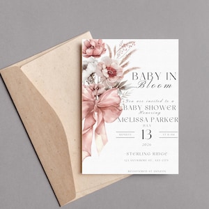Puede incluir: Una invitación a un baby shower con un diseño floral en tonos rosa y blanco. El texto dice "Baby in Bloom" e incluye la fecha y hora del evento, "Lunes, 13 de julio de 2026 a las 11:00 am".
