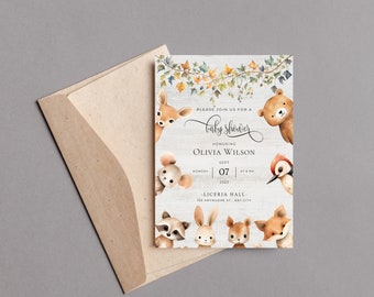 Op de afbeelding: Een uitnodiging voor een babyshower met bosdieren zoals een hert, beer en vos. De uitnodiging bevat de tekst "baby shower" en details voor Olivia Wilson's shower op 7 september 2023. Met een kraft papieren envelop.