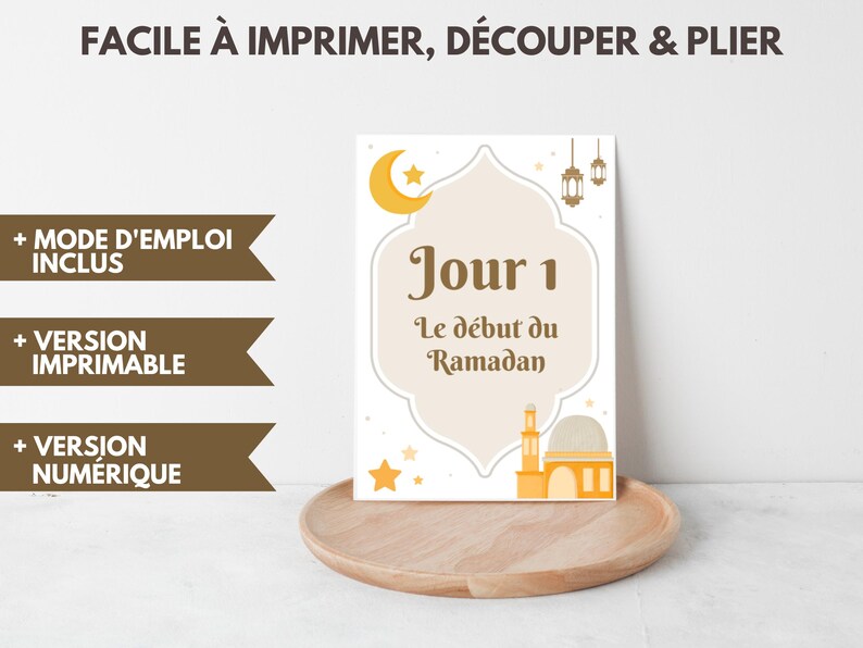 以下が含まれることがあります： 「Jour 1 Le d&eacute;but du Ramadan」のテキストが入った、白とベージュのラマダンをテーマにしたプリント。三日月、星、モスクのイラストが特徴です。「FACILE &Agrave; IMPRIMER, D&Eacute;COUPER & PLIER」の追加テキストが含まれています。