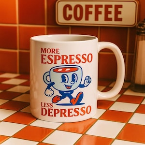 Op de afbeelding: Witte keramische koffiemok met de rode woorden "MORE ESPRESSO LESS DEPRESSO". De mok heeft een cartoon koffiekopje in blauw, rood en zwart. Op de achtergrond is een "COFFEE" bord te zien.
