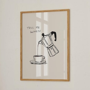 Könnte beinhalten: Ein gerahmter Kunstdruck mit einer Schwarz-Weiß-Illustration einer Kaffeekanne, die Kaffee in eine Tasse und Untertasse gießt. Der Text "TELL ME WHEN" befindet sich über der Kaffeekanne. Das Kunstwerk ist vor einem neutralen Hintergrund.