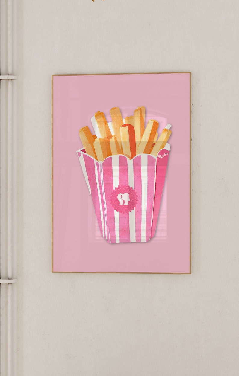 May include: A framed print featuring a pink and white striped container of french fries against a pink background. The fries are yellow and orange. The container has a logo with a silhouette of a woman's head and the word "Barbie".